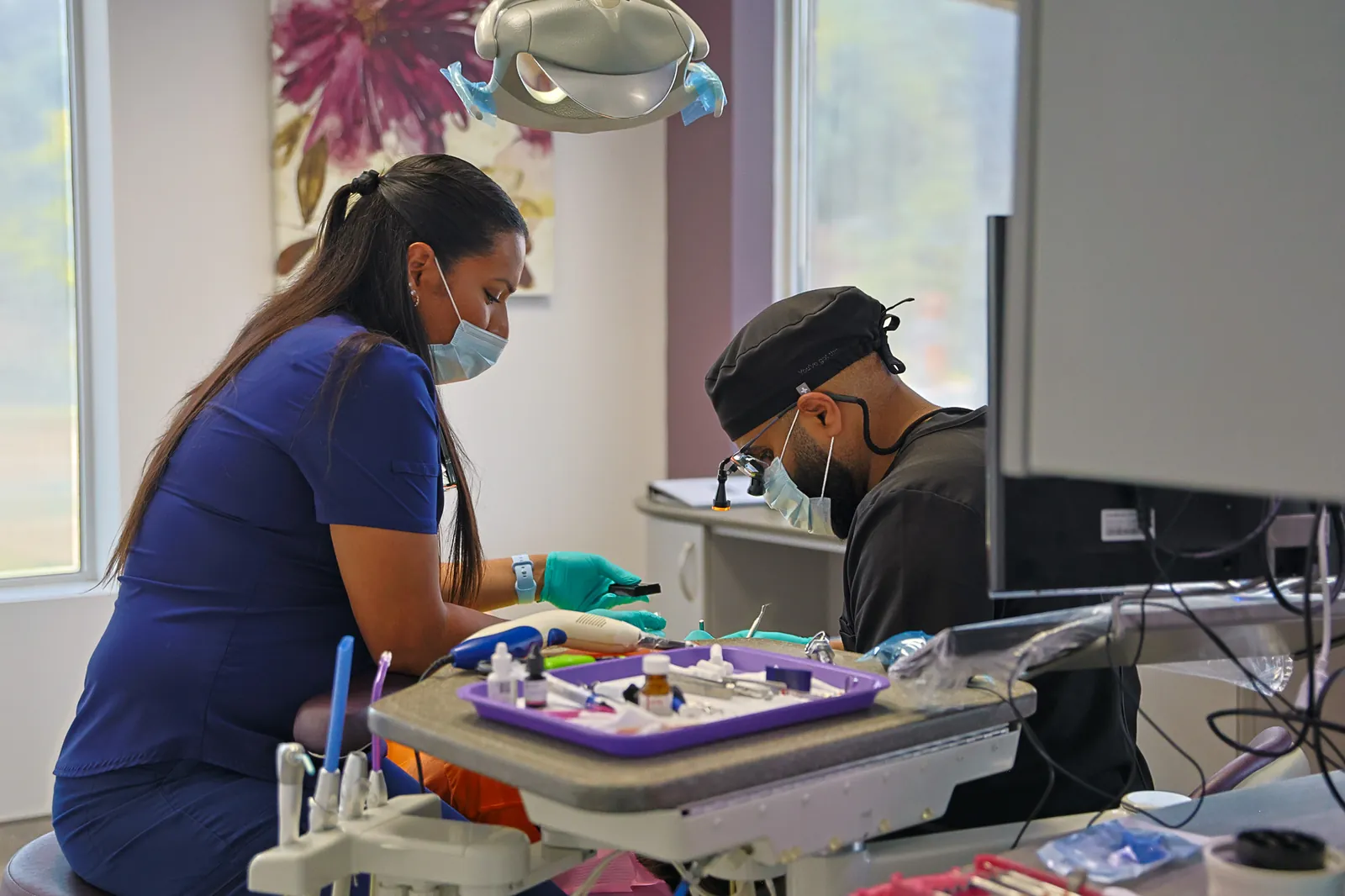 A dentist and dental assistant preparing for treatment at Amherstburg Dental